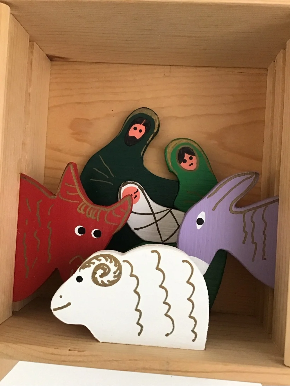 Handmade wooden cabinet holding a small wooden Nativity set